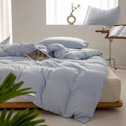 Housse de couette coton lavé bleu ciel sur un lit