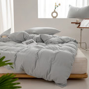 Housse de couette coton lavé gris perle sur un lit