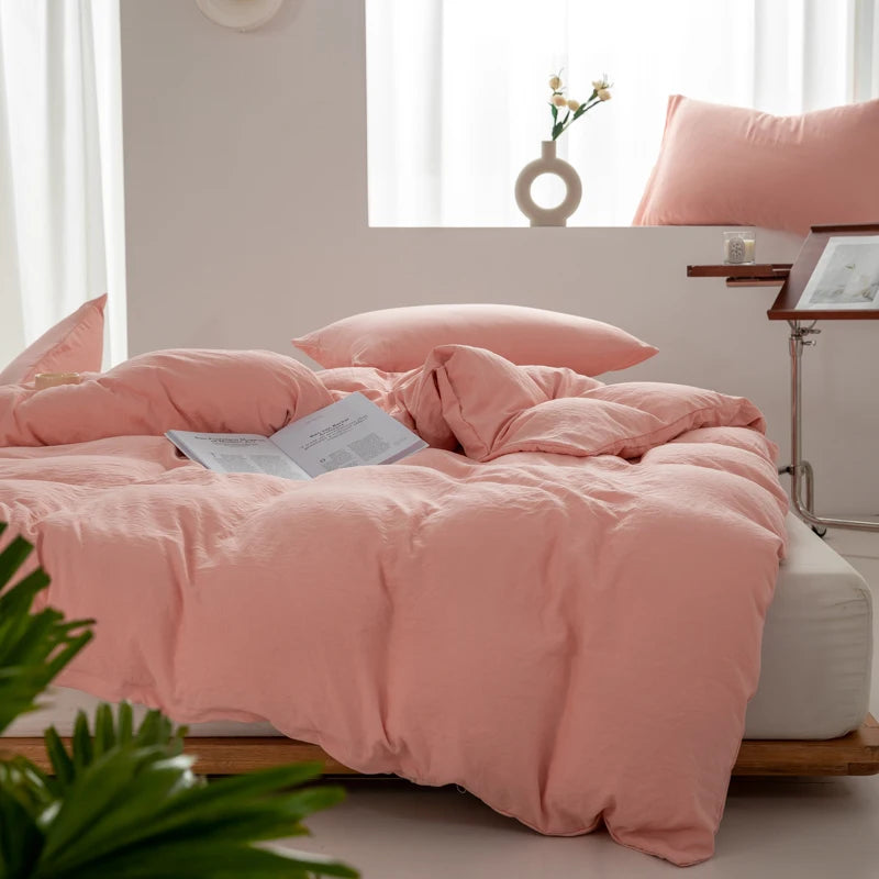 Housse de couette coton lavé rose pêche sur un lit
