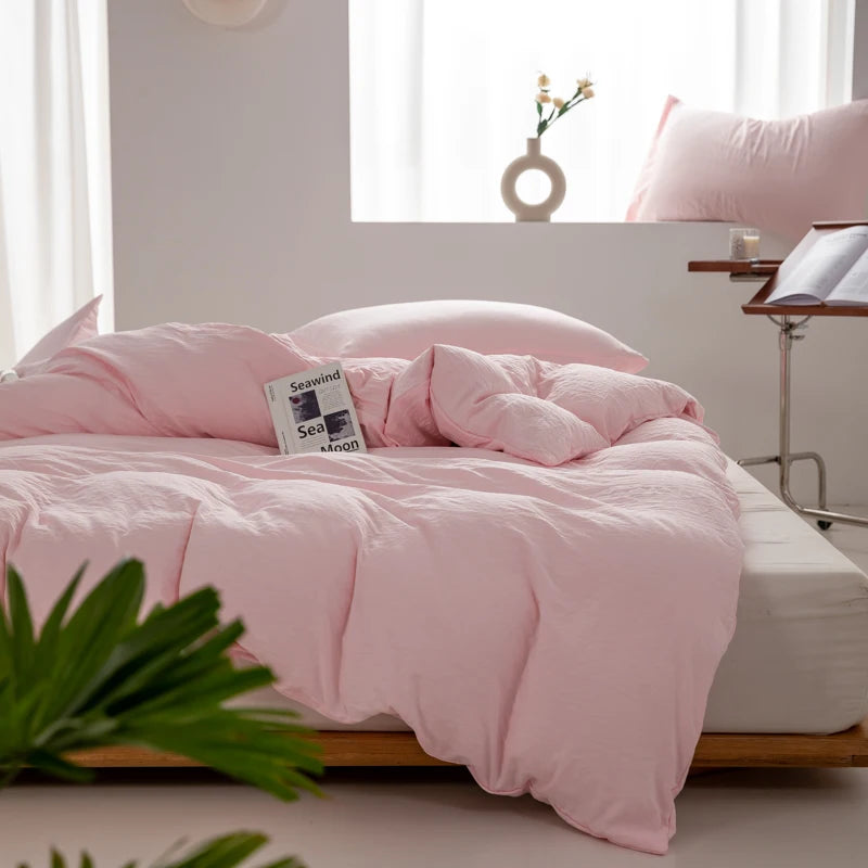 Housse de couette coton lavé rose poudré sur un lit