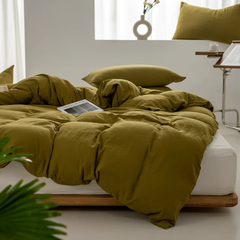 Housse de couette coton lavé vert olive sur un lit