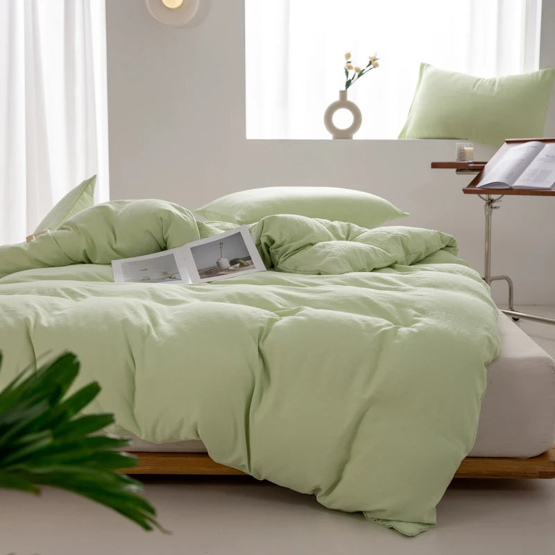 Housse de couette coton lavé vert sauge clair sur un lit