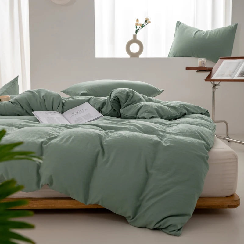 Housse de couette coton lavé vert sauge sur un lit