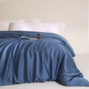 Housse de couette lyocell bleu acier à effet satiné sur un lit