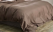 Housse de couette lyocell brun taupe à effet satiné sur un lit