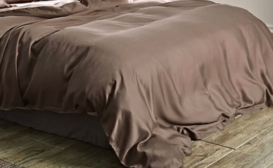 Housse de couette lyocell brun taupe à effet satiné sur un lit