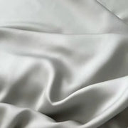 Housse de couette lyocell gris perle à effet satiné sur un lit