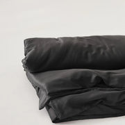 Housse de couette lyocell noire à effet satiné sur un lit