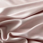 Housse de couette lyocell rose poudré à effet satiné sur un lit