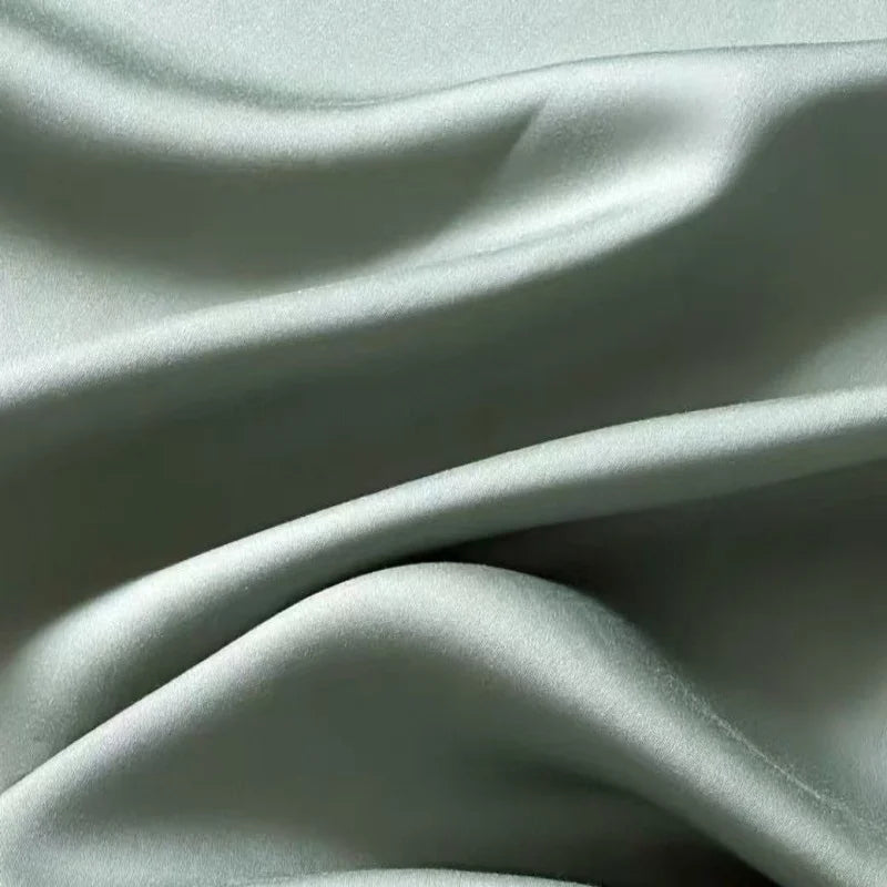 Housse de couette lyocell vert sauge à effet satiné sur un lit